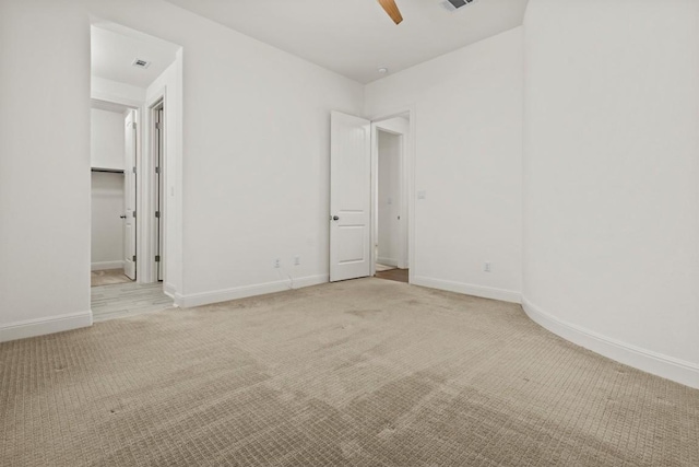 unfurnished room with light carpet, baseboards, and a ceiling fan