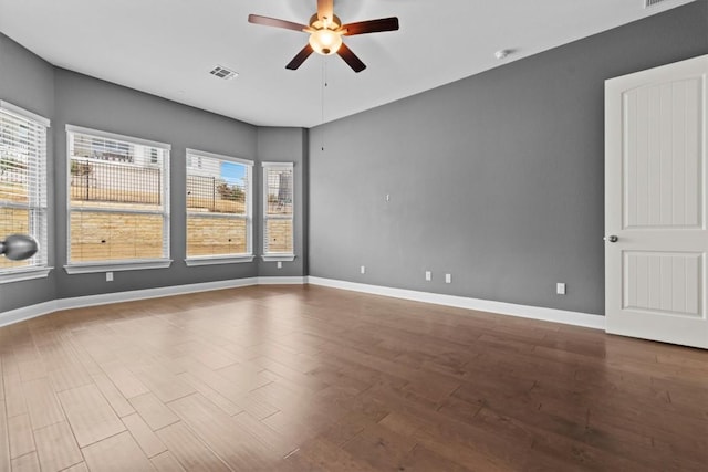 unfurnished room featuring ceiling fan, wood finished floors, and baseboards