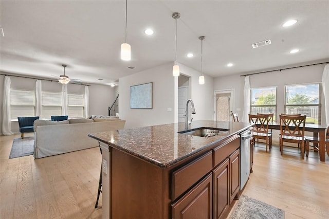 8716 Mina Dr, Austin, TX 78747 - kitchen with stainless steel dishwasher, a ceiling fan, light wood-style floors, recessed lighting, and an island with sink