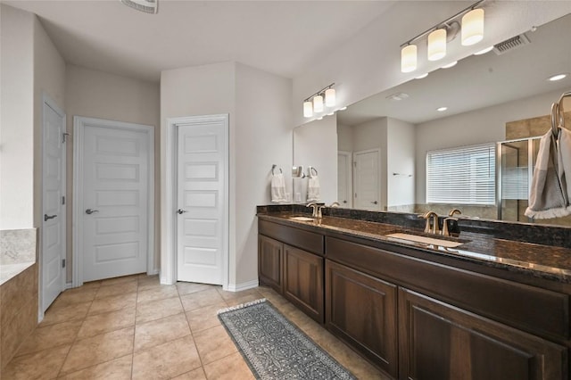 8716 Mina Dr, Austin, TX 78747 - full bathroom with double vanity, a stall shower, tile patterned floors, a closet, and a bath