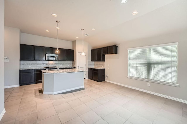 kitchen featuring stainless steel microwave, backsplash, lofted ceiling, light stone countertops, and recessed lighting