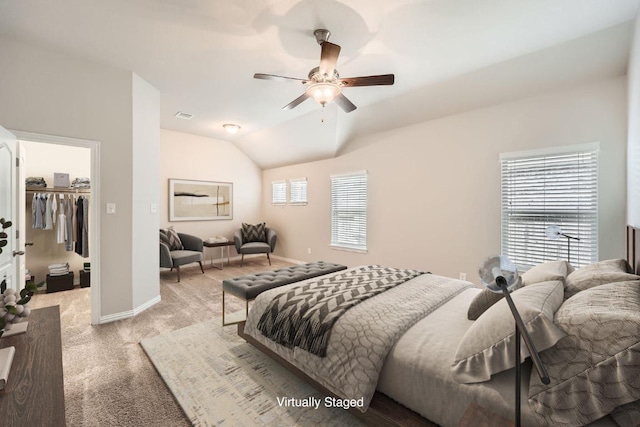 bedroom featuring light carpet, lofted ceiling, ceiling fan, a walk in closet, and baseboards