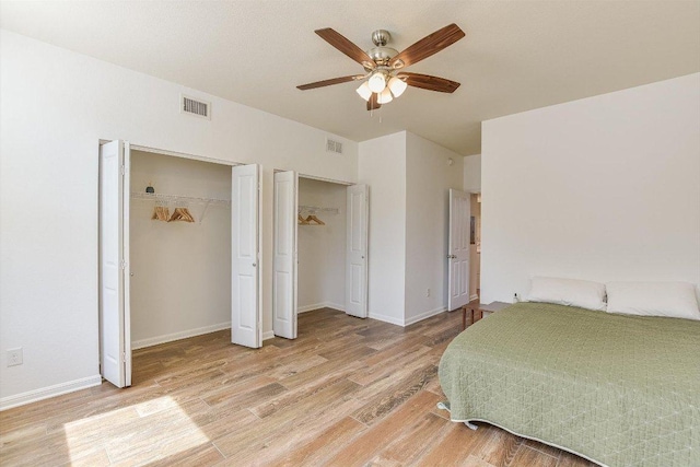 175 Grace St, Kyle, TX 78640 - bedroom with multiple closets, light wood-style floors, a ceiling fan, and baseboards