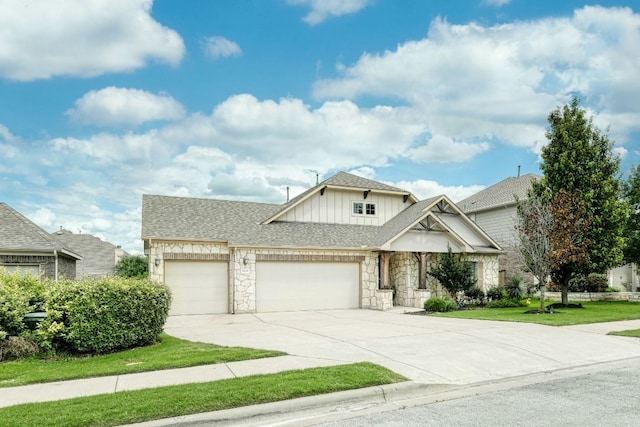 2909 Saint Paul Rivera, Round Rock, TX 78665 - view of front of home featuring board and batten siding, a garage, stone siding, driveway, and a front lawn