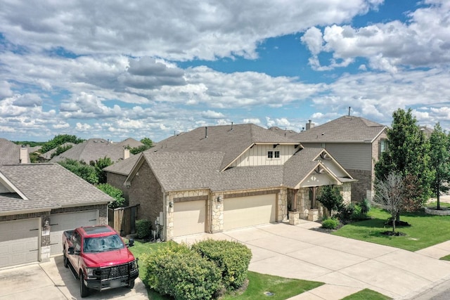 2909 Saint Paul Rivera, Round Rock, TX 78665 - view of front of home with concrete driveway, an attached garage, stone siding, a front lawn, and roof with shingles