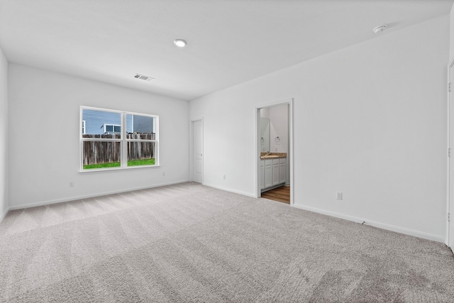 carpeted empty room featuring baseboards and a smoke detector
