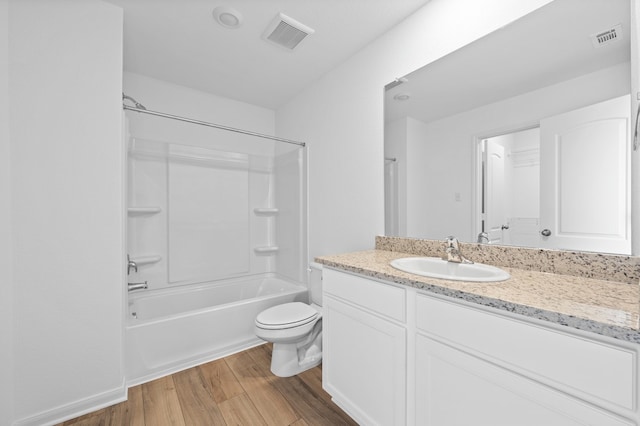 bathroom with wood finished floors, toilet, vanity, and bathtub / shower combination