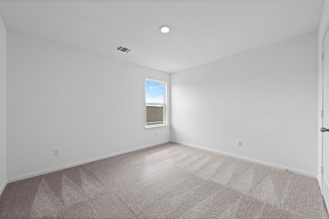 carpeted empty room featuring baseboards