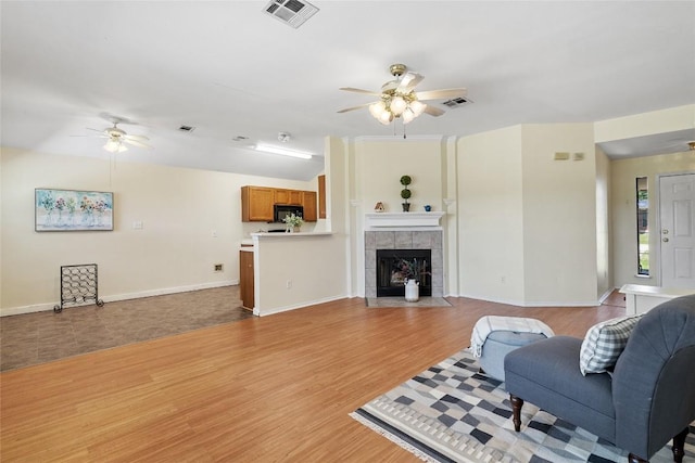 140 Shenandoah Trl, Elgin, TX 78621 - living area featuring a ceiling fan, light wood-style floors, baseboards, and a tile fireplace