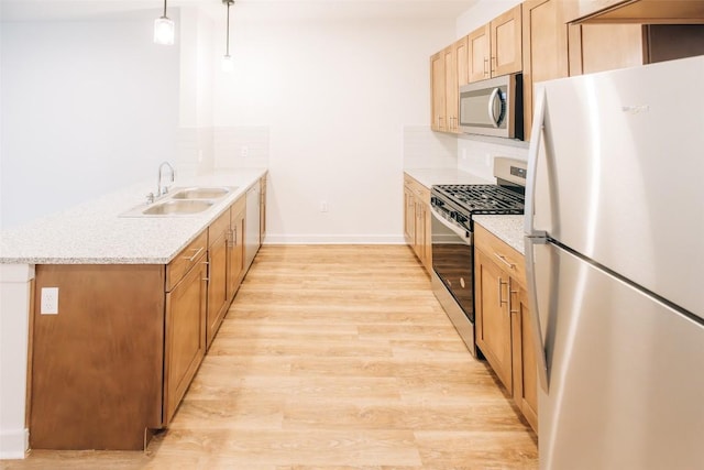 7051 Meadow Lake Blvd Unit 8203, Austin, TX 78744 - kitchen with appliances with stainless steel finishes, a sink, a peninsula, light wood finished floors, and backsplash