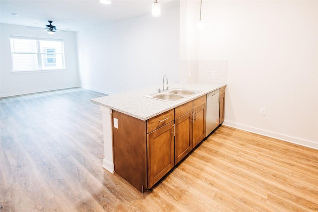 7051 Meadow Lake Blvd Unit 8203, Austin, TX 78744 - kitchen with a sink, dishwasher, light wood-style flooring, brown cabinetry, and decorative light fixtures