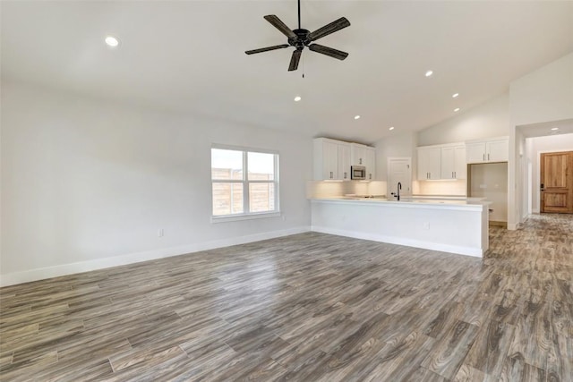9601 Eloquence Dr, Manor, TX 78653 - unfurnished living room with wood finished floors, ceiling fan, recessed lighting, and high vaulted ceiling