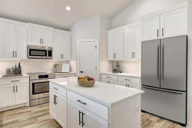 9601 Eloquence Dr, Manor, TX 78653 - kitchen featuring stainless steel appliances, tasteful backsplash, light countertops, white cabinetry, and lofted ceiling