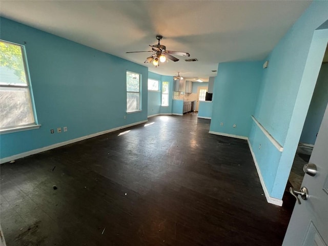 7205 Bethune Ave, Austin, TX 78752 - unfurnished living room with ceiling fan, baseboards, and dark wood-style floors