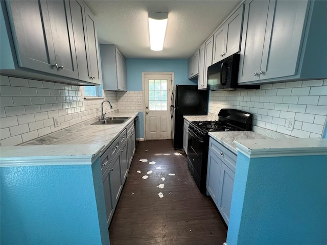 7205 Bethune Ave, Austin, TX 78752 - kitchen featuring black appliances, a sink, dark wood-type flooring, and backsplash