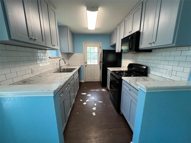 7205 Bethune Ave, Austin, TX 78752 - kitchen featuring black appliances, a sink, dark wood-style flooring, and decorative backsplash