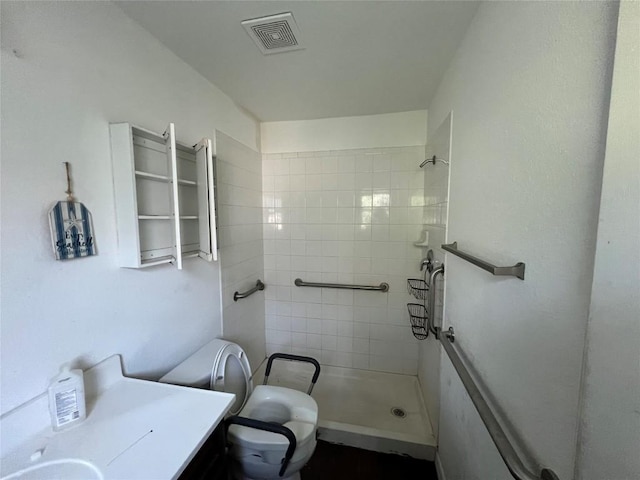 7205 Bethune Ave, Austin, TX 78752 - bathroom featuring tiled shower, toilet, and vanity