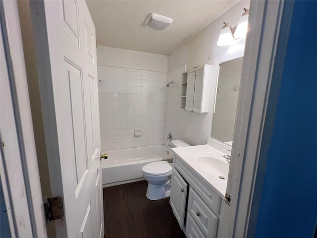 7205 Bethune Ave, Austin, TX 78752 - bathroom with toilet, wood finished floors, vanity, and bathing tub / shower combination