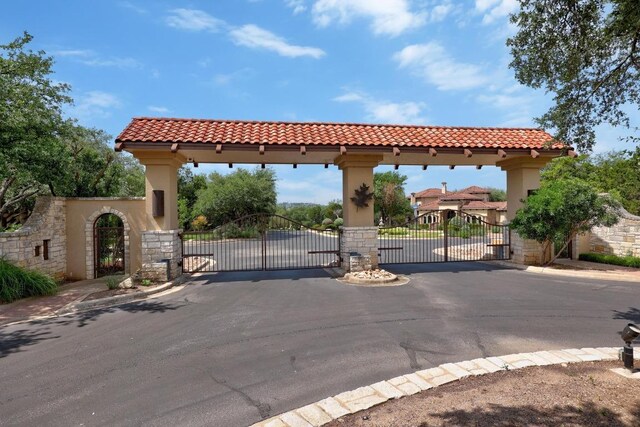 106 Sendera Bonita, Austin, TX 78734 - view of asphalt street featuring a gate, a gated entry, curbs, and sidewalks
