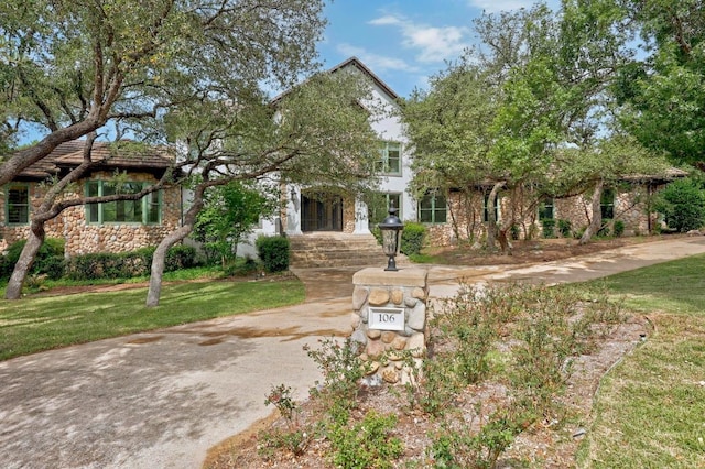 106 Sendera Bonita, Austin, TX 78734 - view of property hidden behind natural elements with stone siding and a front lawn
