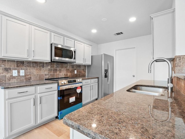 109 Orange Tree Ln, Georgetown, TX 78626 - kitchen with appliances with stainless steel finishes, a sink, dark stone countertops, backsplash, and recessed lighting