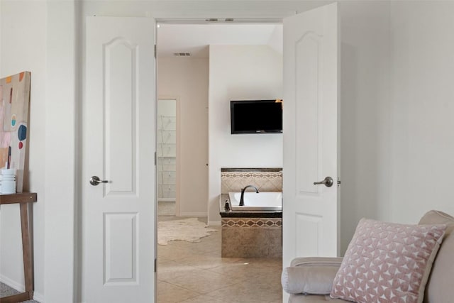 corridor featuring tile patterned floors and baseboards