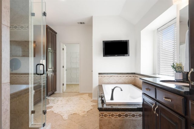 full bath featuring vanity, a stall shower, a garden tub, tile patterned flooring, and vaulted ceiling