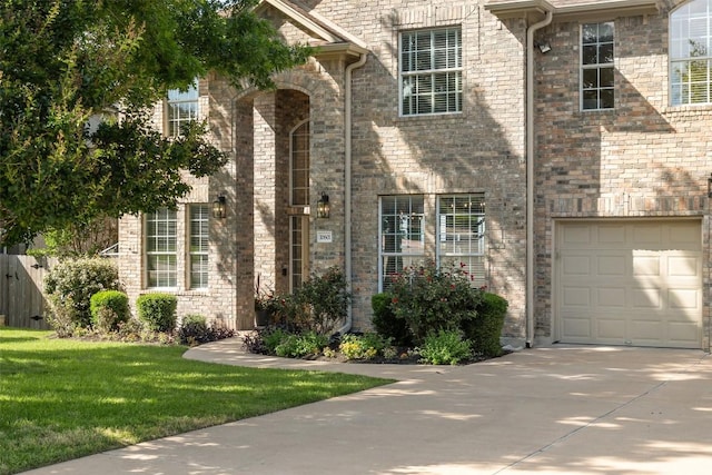 view of front facade with an attached garage, concrete driveway, and a front lawn