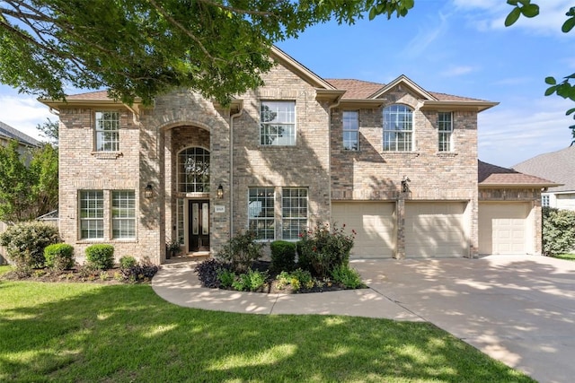 traditional-style house with driveway, a front yard, and brick siding