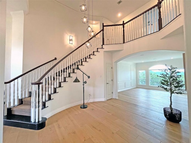 9604 Big View Dr, Austin, TX 78730 - stairway featuring a high ceiling, wood finished floors, arched walkways, and recessed lighting