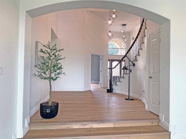 9604 Big View Dr, Austin, TX 78730 - foyer entrance featuring wood finished floors, stairway, arched walkways, and a towering ceiling