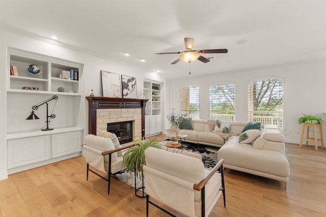 9604 Big View Dr, Austin, TX 78730 - living area featuring a ceiling fan, light wood finished floors, built in shelves, a stone fireplace, and crown molding