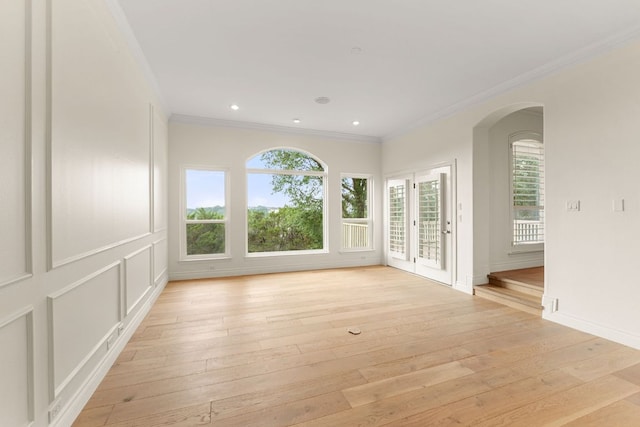 9604 Big View Dr, Austin, TX 78730 - unfurnished room featuring plenty of natural light, crown molding, light wood-style flooring, arched walkways, and recessed lighting