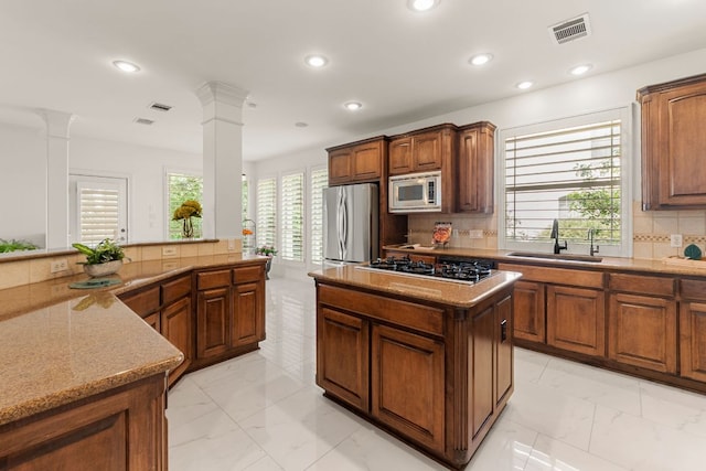 9604 Big View Dr, Austin, TX 78730 - kitchen with stainless steel appliances, ornate columns, a kitchen island, backsplash, and recessed lighting