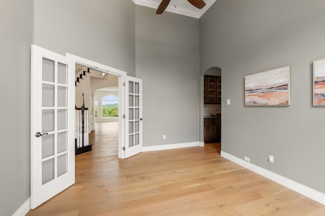 9604 Big View Dr, Austin, TX 78730 - unfurnished room featuring french doors, a high ceiling, arched walkways, ceiling fan, and light wood-style flooring