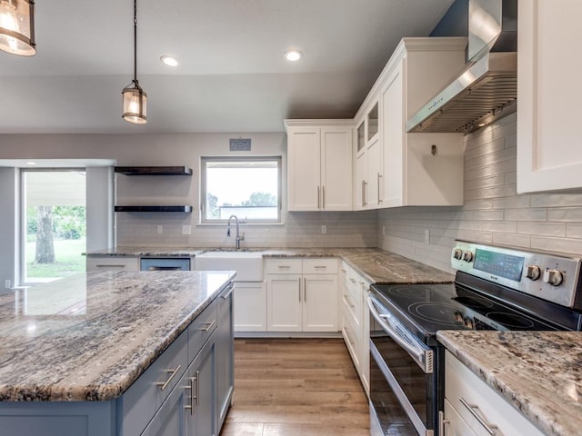 16721 Decker Creek Dr, Manor, TX 78653 - kitchen featuring stainless steel electric range, wall chimney range hood, white cabinetry, recessed lighting, and light wood finished floors