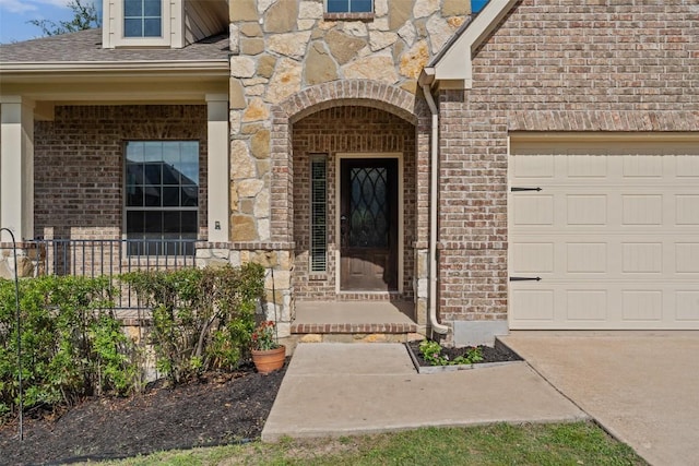 21816 Agarito Ln, Spicewood, TX 78669 - doorway to property featuring brick siding, an attached garage, driveway, stone siding, and a shingled roof