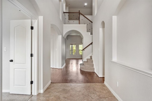 21816 Agarito Ln, Spicewood, TX 78669 - foyer entrance featuring stairway, arched walkways, a high ceiling, and baseboards