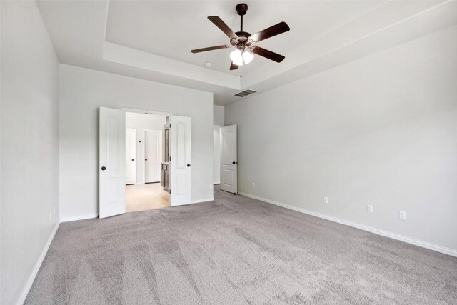 21816 Agarito Ln, Spicewood, TX 78669 - unfurnished bedroom featuring a tray ceiling, carpet, and baseboards