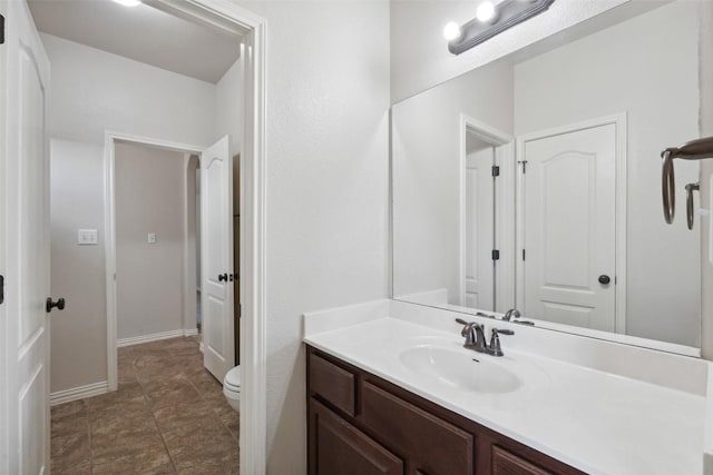 21816 Agarito Ln, Spicewood, TX 78669 - bathroom featuring toilet, vanity, and baseboards