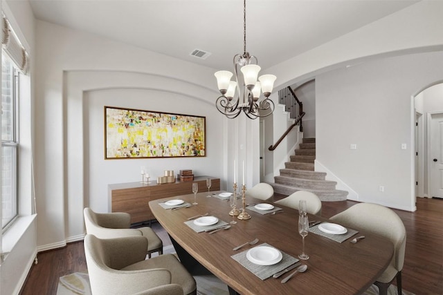 21816 Agarito Ln, Spicewood, TX 78669 - dining space with arched walkways, a chandelier, wood finished floors, stairs, and baseboards