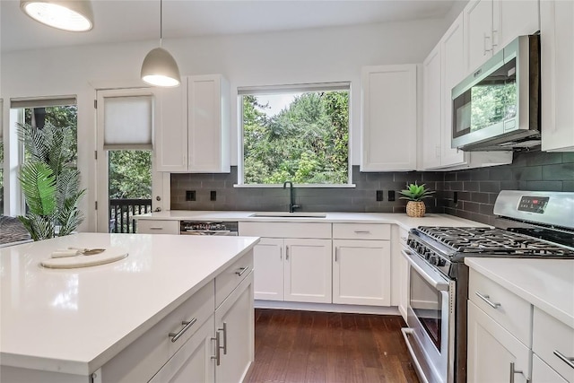 4612 Windy Brook Dr Unit A, Austin, TX 78723 - kitchen with stainless steel appliances, a sink, light countertops, backsplash, and dark wood finished floors