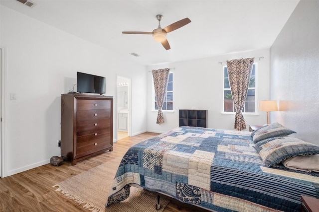 146 Long Shadow Dr, Bastrop, TX 78602 - bedroom with wood finished floors, baseboards, a ceiling fan, and ensuite bath