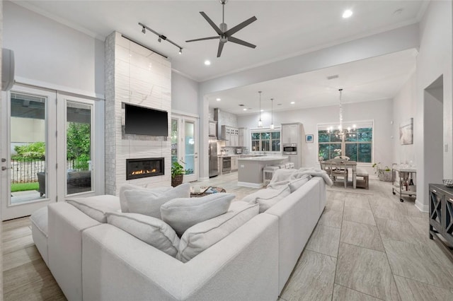 15004 Falconhead Grove Loop, Austin, TX 78738 - living room featuring ceiling fan, a chandelier, a fireplace, recessed lighting, and ornamental molding