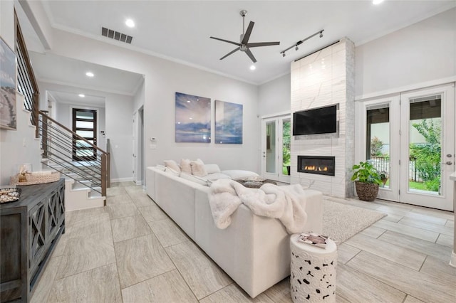 15004 Falconhead Grove Loop, Austin, TX 78738 - living room featuring ceiling fan, a fireplace, stairs, recessed lighting, and crown molding