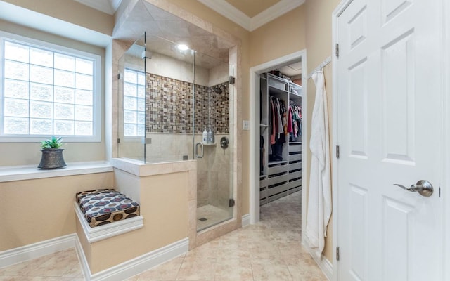 bathroom with a shower stall, crown molding, a walk in closet, baseboards, and tile patterned floors