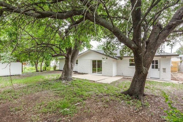 5711 Wellington Dr, Austin, TX 78723 - rear view of house featuring brick siding and a patio