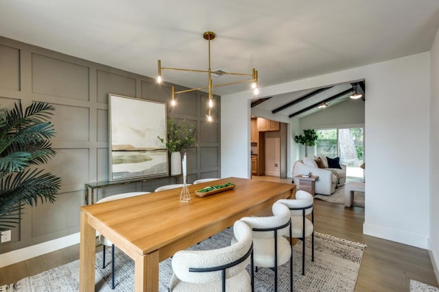 5711 Wellington Dr, Austin, TX 78723 - dining room featuring wood finished floors, lofted ceiling, and a decorative wall