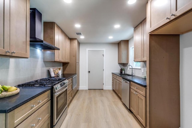 5711 Wellington Dr, Austin, TX 78723 - kitchen with wall chimney exhaust hood, stainless steel appliances, dark countertops, light wood-style flooring, and tasteful backsplash