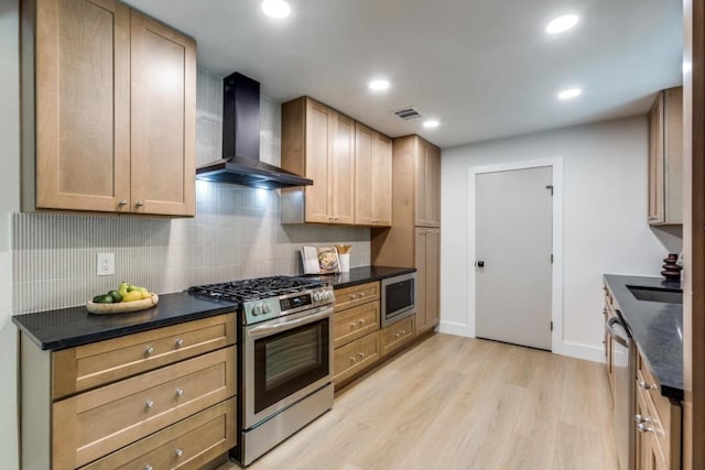 5711 Wellington Dr, Austin, TX 78723 - kitchen with wall chimney exhaust hood, appliances with stainless steel finishes, tasteful backsplash, light wood finished floors, and recessed lighting